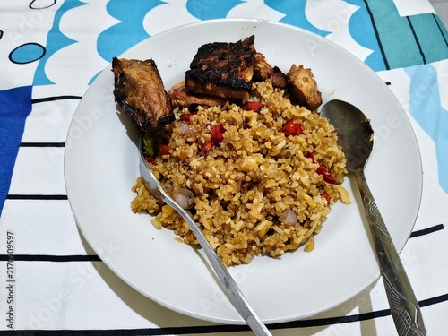 Fotografie Indonesian fried rice with fried tempeh on white plate