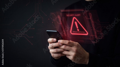 Person holding a smartphone displaying red digital security breach alert hologram against a dark background with abstract glowing circuit patterns