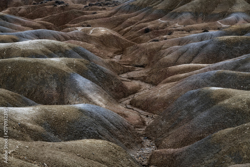 Quadro su tela Overhead view of dry, eroded badlands with textured hills and a winding ravine