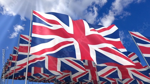 Multiple United Kingdom flags waving on blue sky