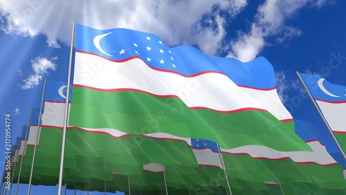 Multiple Uzbekistan flags waving on blue sky