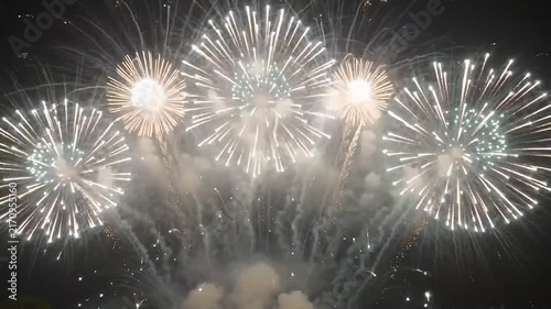 Bright Golden and White Fireworks Display Illuminating the Night Sky for Holidays
