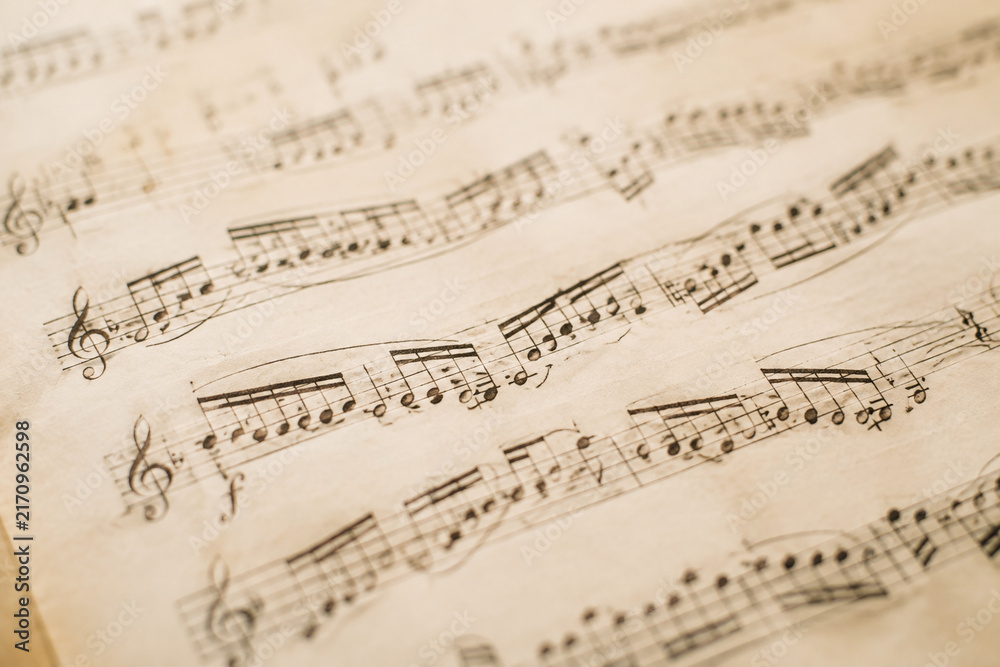 Fototapeta premium Classical music manuscript with flowing notes on aged paper.