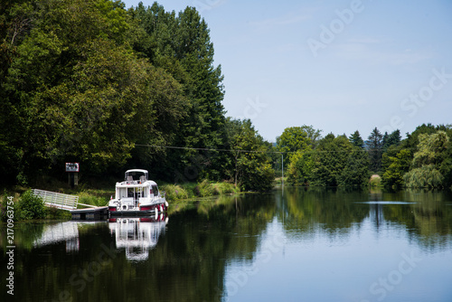Bateau de croisière sur un canal. Vacances sur une voie navigable. Se déplacer en bateau. Petit bateau sur l'eau.