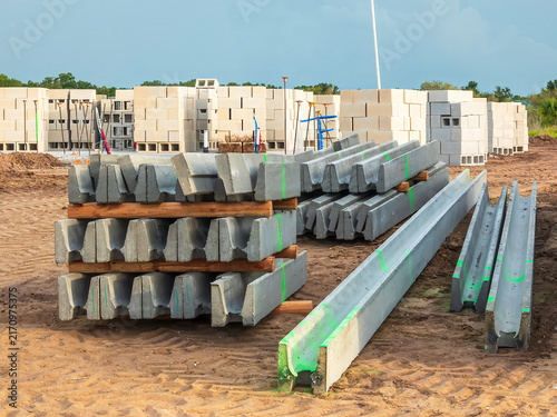 Precast concrete lintels (for horizontal support above doors, windows, and other openings) near stacks of concrete blocks for construction of a house in a suburban residential development in Florida