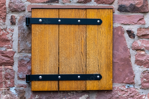 Wooden shutter on a stone wall showing craftsmanship in building design