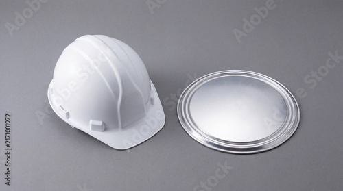 White construction helmet and metallic circular shield provide feeling of organized preparation and professional industrial safety