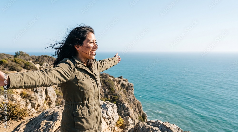 Obraz premium Guatemalan American Woman Arms Outstretched Cliffside Overlook Copy Space