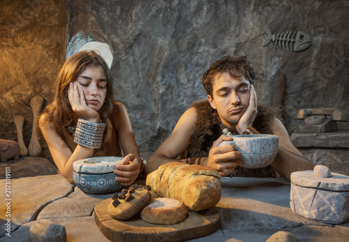 Fotografía Sad Stone Age young couple having an early breakfast