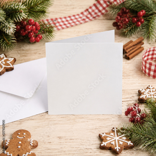 Festive holiday cookies and blank card on a rustic table. Perfect for seasonal greetings and cozy gatherings.