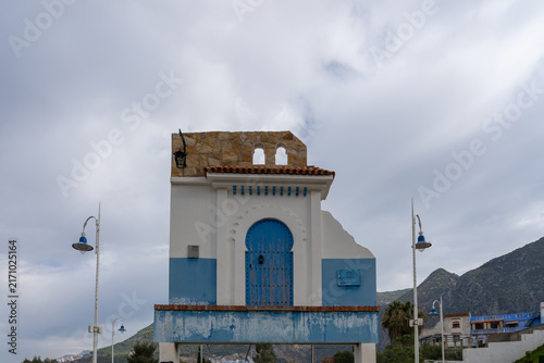
A traditional ornate Moroccan wooden blue door and facade  referred to as a symbolic 
