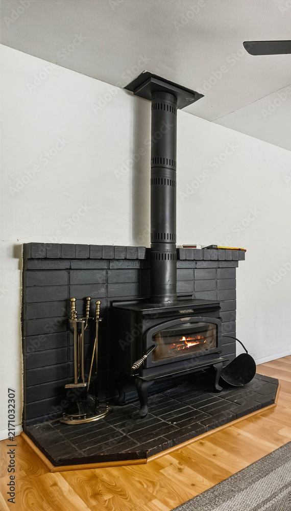Naklejka premium Wood stove in a modern living room with brick hearth