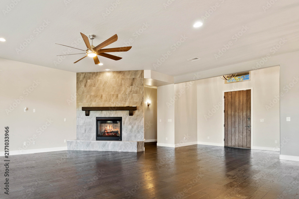 Naklejka premium Spacious living room with stone fireplace and ceiling fan