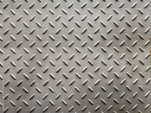A close-up view of industrial diamond plate metal with a raised safety pattern.