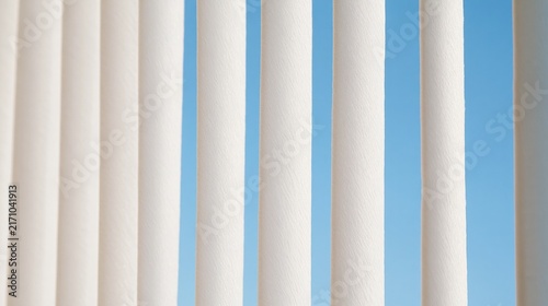Sturdy marble pillars stand tall before a bright summer sky demonstrating classic architectural strength and historical permanence found within the grandeur of ancient greek or roman building