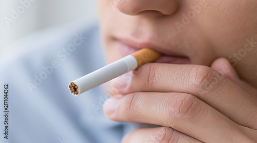 Close-up of a person holding a cigarette, highlighting smoking habits and personal choices in a modern lifestyle.