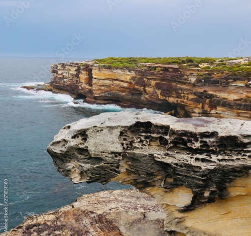 Fotografie Dramatic sandstone cliffs and rocky coastline along the cape Baily Track in Kama