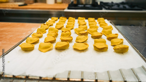 Quadro su tela Artisanal tortelli pasta resting on baking paper, showing the detailed process o