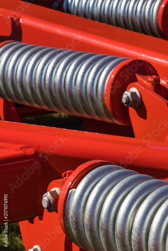 Steel silver spring as part of heavy agricultural, industrial machine. Technology
