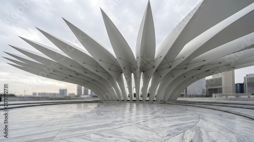Modern architectural structure with a futuristic white canopy design and a reflective water surface in the foreground