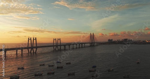 Cinematic Aerial Drone View of vehicles passing over the Bandra-Worli Sea Link at golden sunset over the Arabian Sea, Mumbai, India.