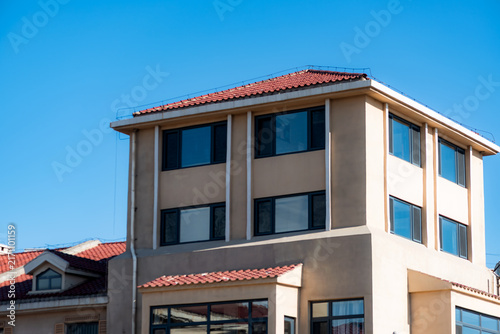 Exterior of multi‑story detached villa under clear blue sky