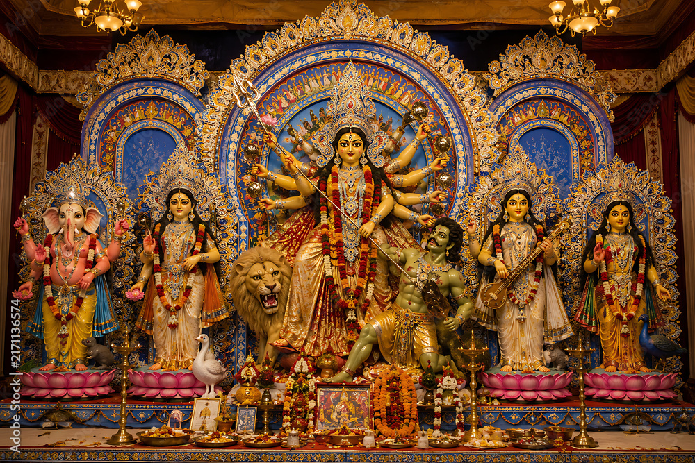 Fototapeta premium Elaborate Durga Puja Pandal Displaying Goddess Durga Defeating Mahishasura Surrounded by Ganesha, Lakshmi, Saraswati, and Kartikeya During Navratri Festival Celebrations