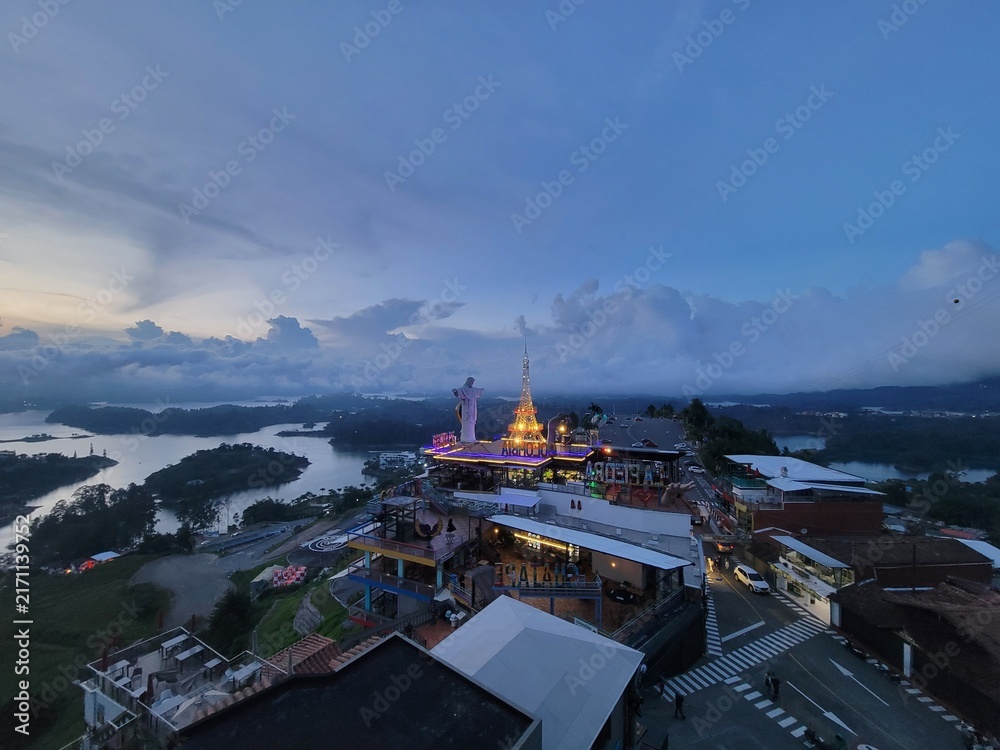 Naklejka premium Hilltop complex and illuminated temple at dusk overlooking a reservoir