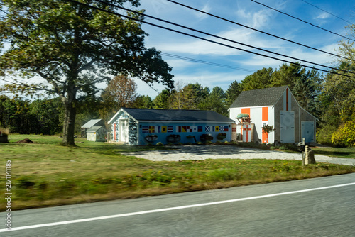 Country main road fading into the horizon distance on a blue sky day, Maine