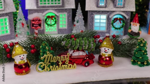 A small and unusual Santa Claus rides in front of a beautiful Christmas village