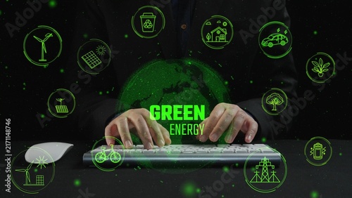 Fotografie Dynamic image depicting hands typing on a keyboard with glowing green energy icons surrounding a globe, emphasizing the importance of renewable energy and sustainability
