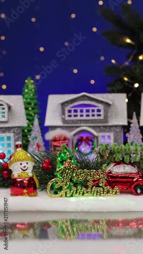A yellow car with a Christmas tree on the roof enters a Christmas town