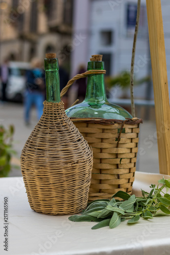 Foto Mosciano Sant'Angelo, Italy - October 26, 2025: Traditional glass wine demijohns in wicker baskets
