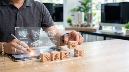Urban planner designing stormwater management system with digital tablet and wooden blocks