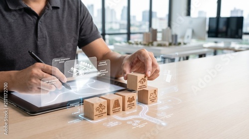 Architect planning residential project with wooden blocks and digital tablet in office