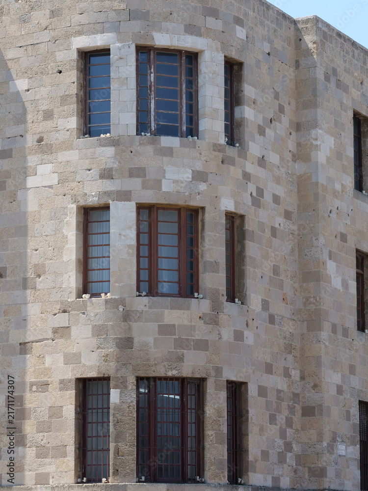 Fototapeta premium Symmetric curved brick wall architecture with dark window frames