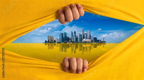 Hands pulling apart yellow fabric to reveal a modern city skyline reflected in water with uncover cityscape reflections