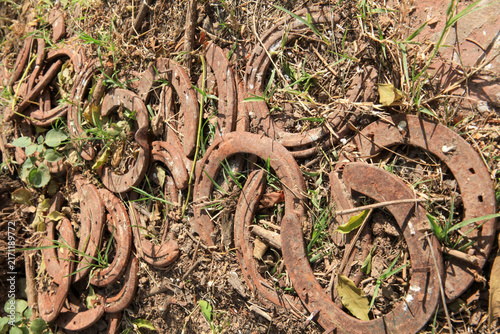 Fotografía Herraduras de caballo viejas y oxidadas esparcidas en el suelo entre la tierra y