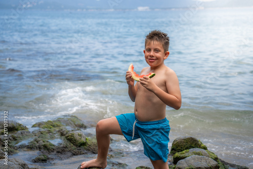Obraz na plátne niño pequeño latino rubio sonriente disfrutando de una deliciosa rebanada de san