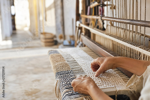 Fotografía Artisan weaving textured textile on traditional loom