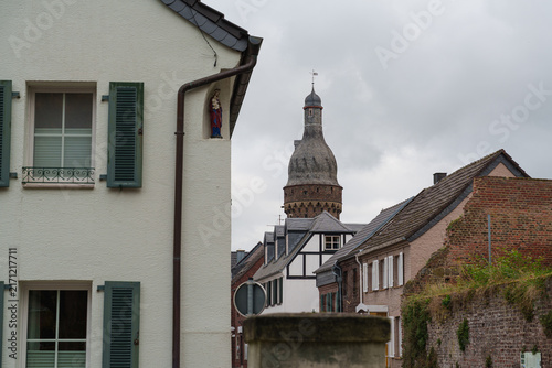 Принти на полотні Historic houses line a narrow street leading toward a Juddeturm tower in Zons