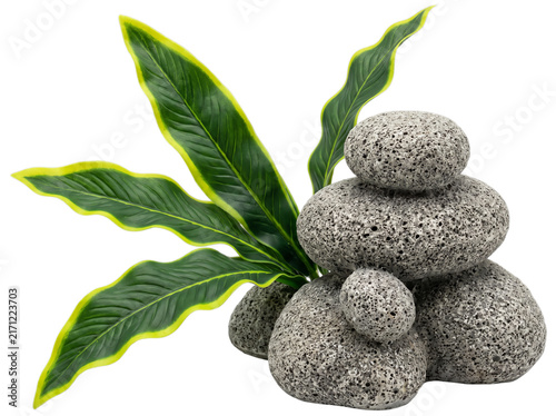 Zen basalt stones with tropical green leaves, stacked pebble balance on white background, spa and wellness concept