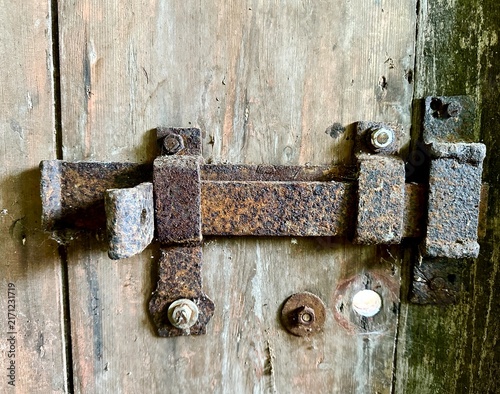 Fotografía A close-up of an old, rusty metal door trim on a wooden door.