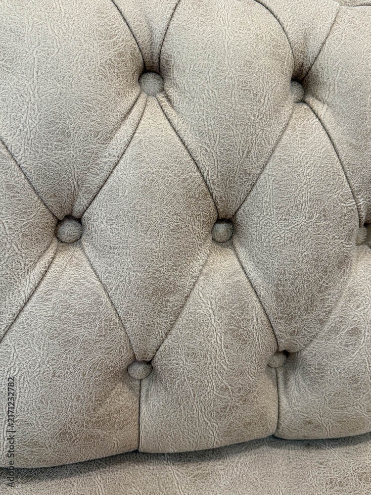 Naklejka premium Tufted beige leather upholstery with diamond pattern, suitable for texture or interior design background