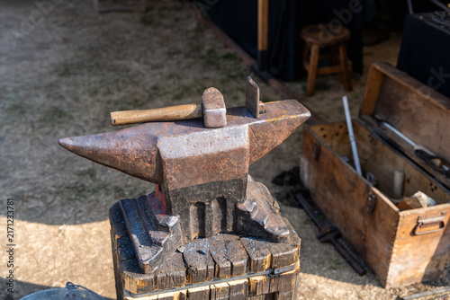 Traditional steel anvil with a hammer resting on its surface. Blacksmithing equipment, craftsmanship, forging, skilled trades and traditional manufacturing.