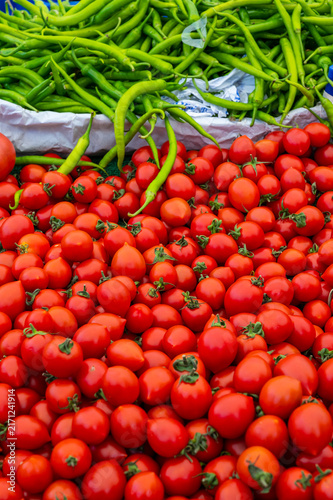Quadro su tela Stacked fresh cherry tomatoes glow red, green chilies line top