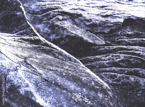 Dark abstract background with rugged stone, rock, and textured mineral surfaces