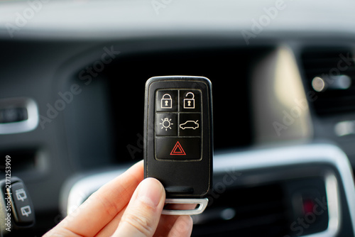 Volvo key fob being inserted into the dashboard slot next to the chrome Start Stop button