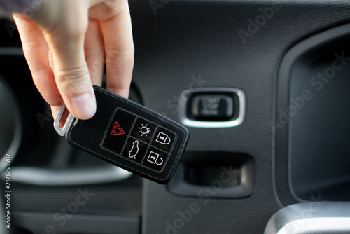 Volvo key fob being inserted into the dashboard slot next to the chrome Start Stop button