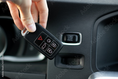 Volvo key fob being inserted into the dashboard slot next to the chrome Start Stop button